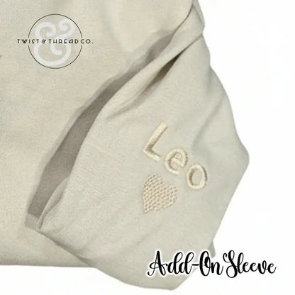 Cream-colored fabric sleeve with embroidered name 'Leo' and heart, branded Twist & Thread Co