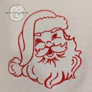 red embroidered Santa Claus face on white fabric with Twist & Thread Co. logo