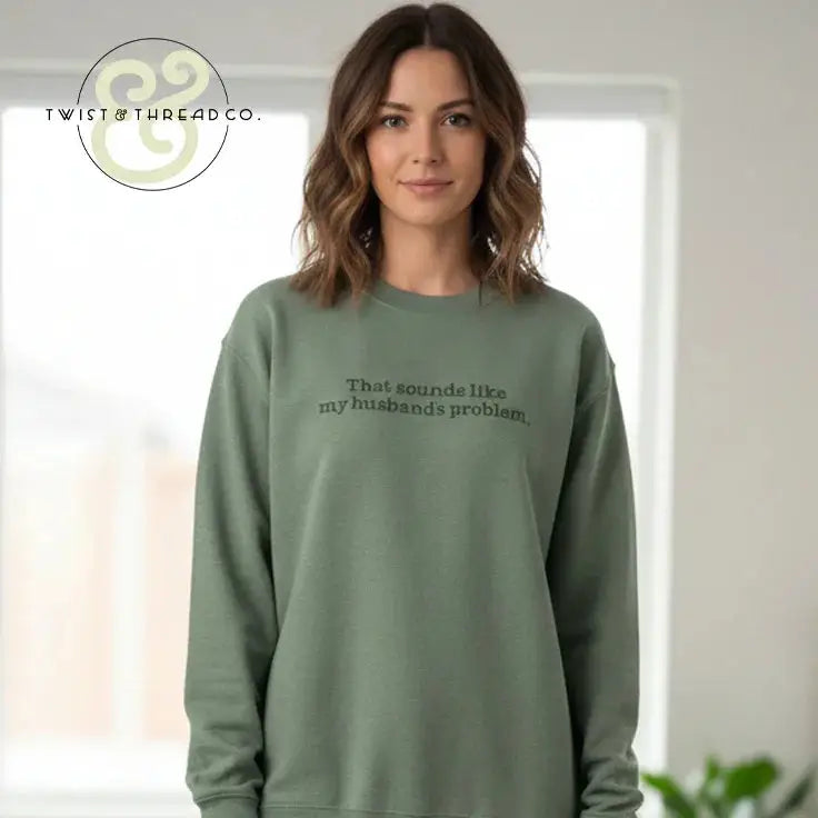 Woman wearing green sweatshirt with 'That sounds like my husband's problem' text, indoor natural light