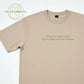 Beige T-shirt with text 'That sounds like my husband's problem' printed on front, laid flat on white background