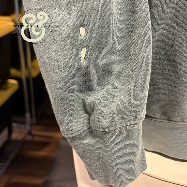 Custom embroidered sage green hoodie sleeve with semicolon design by Twist & Thread Co.