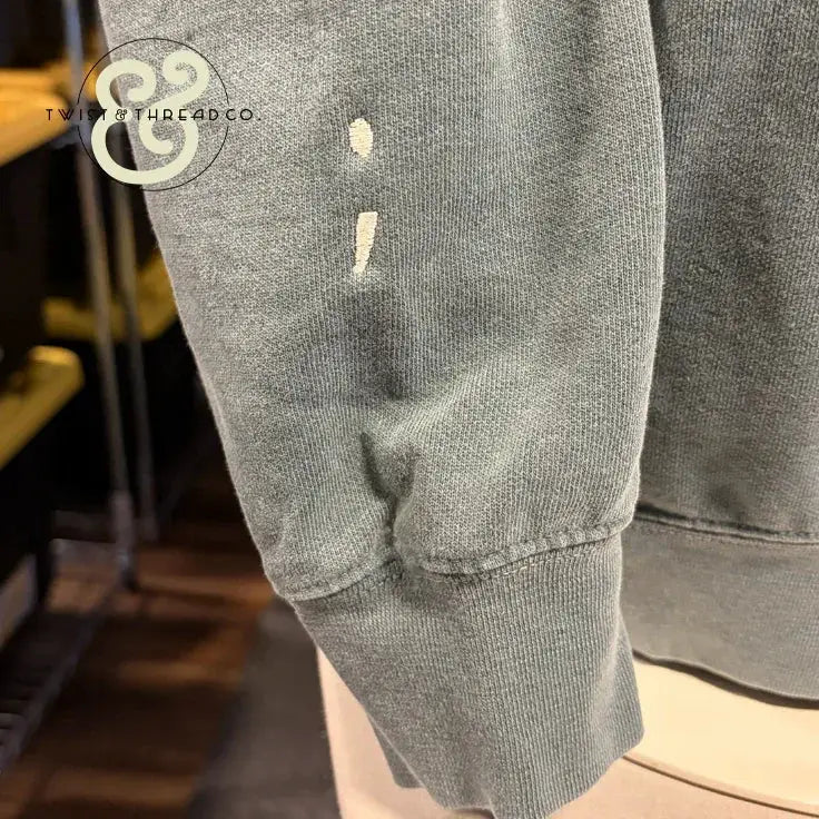 Custom embroidered sage green hoodie sleeve with semicolon design by Twist & Thread Co.
